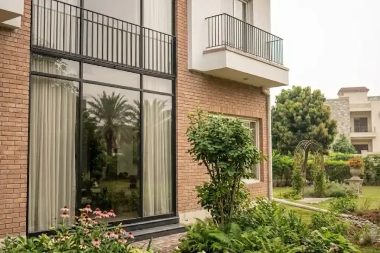 Modern Juliet balcony with a black metal railing across a tall glass door on a house exterior