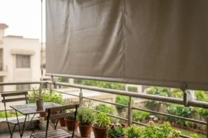 Waterproof PVC roller blind installed on a rainy outdoor balcony, blocking wind and rain