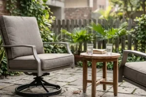 Aluminum swivel chair garden furniture on a flat stone patio with a small teak side table